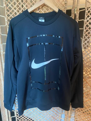 Nike Tennis Träningströja - Säljer en Träningströja från Nike tennis i dry-fit material. Tröjan är i storlek medium och passformen är slim.