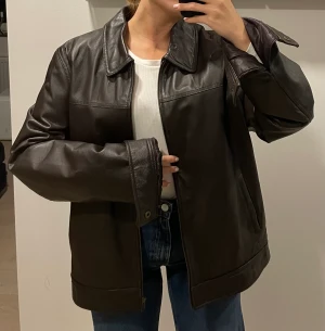Skinnjacka - Jättefin mörkbrun skinnjacka i 100% läder. Står storlek XL men har använt den som oversized. Köpt för 1500kr.   Skriv för fler bilder!   