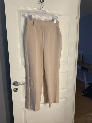 Byxor från NA-KD  - Ljusa beiga byxor med hög midja och ankellängd. 
