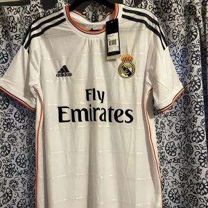 Real Madrid 2013/14 - Helt ny tröja, hemställ real Madrid 2014 året dem vann Champions league. Skick 10/10, helt ny aldrig använd.