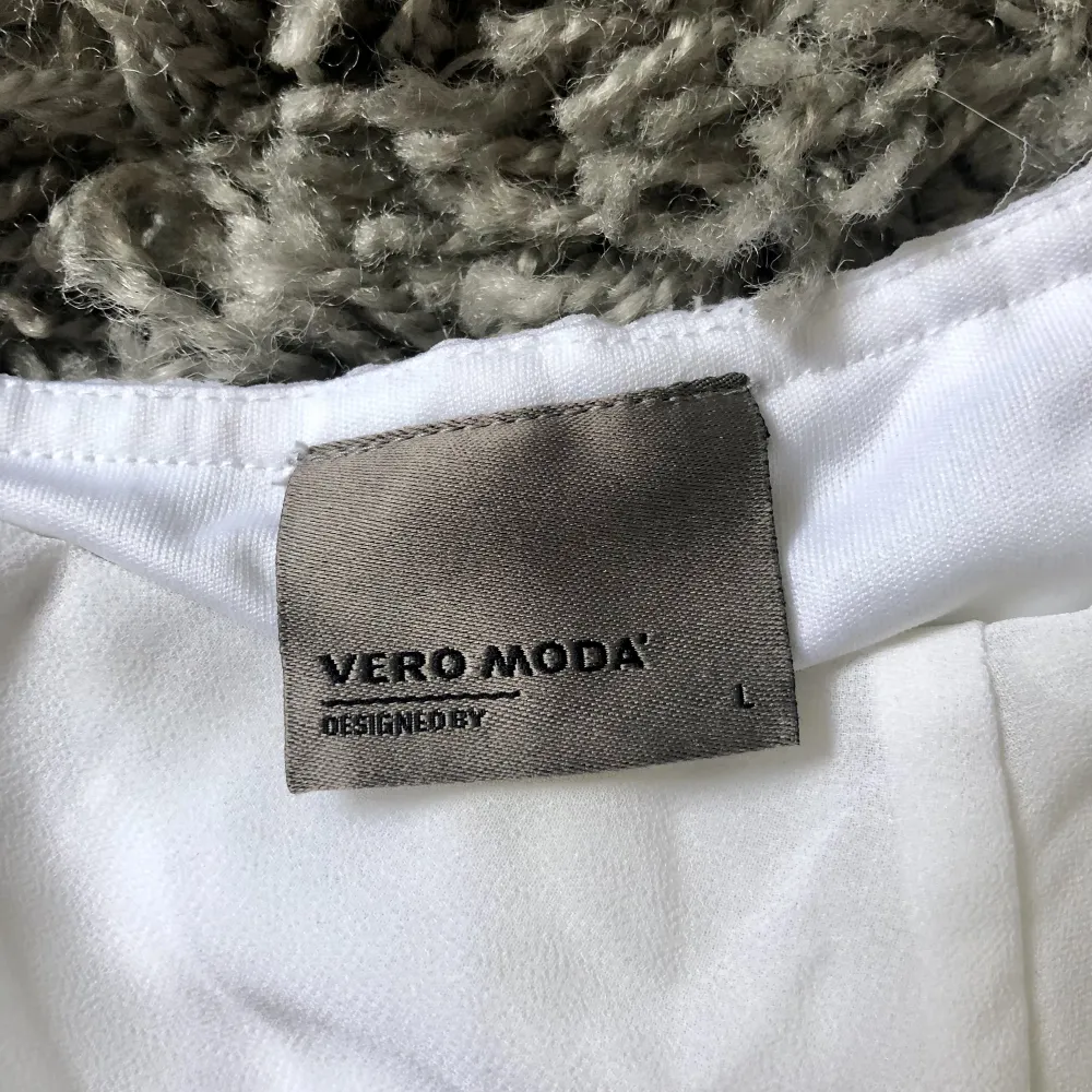 Vit klänning från Vero Moda i storlek L. Axelbanden går i kors på ryggen. Använd högst 3 ggr sen köpt. Katt finns i hemmet. (Smycken ingår inte.). Klänningar.