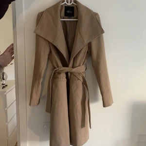 Beige kappa  - Snygg kappa i storlek M, använd några gången men i väldigt fint skick! De första två bilderna är den rättvisa färgen på jackan!  Köpt i en butik i Prag. Nypris: 1000kr  