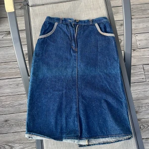 Snygg jeanskjol - Högmidjad, knälång mörkblåjeanskjol från märket LAWSON Jeans. Är i bra skick. Köpt second hand på Beyond Retro event.