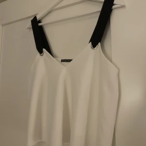 Topp från Zara - En snygg vit topp från zara med svarta axelband i storlek M💕