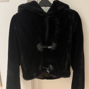Pälsjacka - En jätte skön pälsjacka vet tyvärr inte vart den är ifrån. Fint skicka förutom att den här saken man knäpper med har gått av lite men det går fortfarande att knäppa så det är inget synligt.