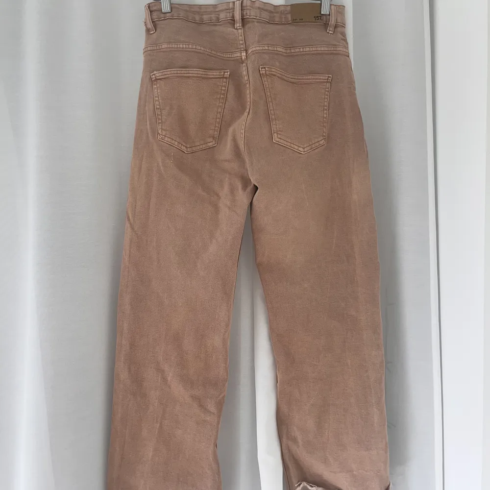 Ett par beige/bruna jeans som är högmidjade och vida i benen. De går precis över ankeln på mig och jag är 170 cm lång. Säljs då de inte kommer till användning! ⭐️. Jeans & Byxor.