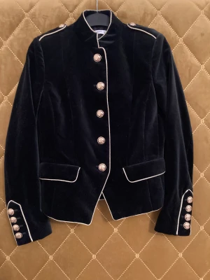 Kavaj, MANGO  - Kort kavaj från MANGO. Velour tyg, väldigt mörkt marinblå med guld detaljer, strl S. Aldrig använd! Köparen står för frakt 