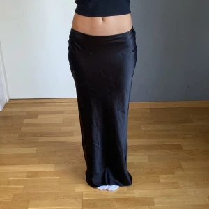 Satin långkjol - Svart lågmidjad satin långkjol, går hela vägen till marken på mig som är 165. Storlek S ✨🙏