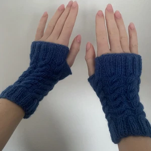 Stickade handledsvärmare med flätor - Stickade handledsvärmare som stickas på beställning i vilken färg som helst. Har flätor och tumhål.