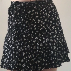 Svart och vit blomig tjol från zara - Säljer den har gulliga tjolen för den har blivit för stram i midjan, men fin ändå!, den har shorts inuti  tjolen💝 (läs bio)