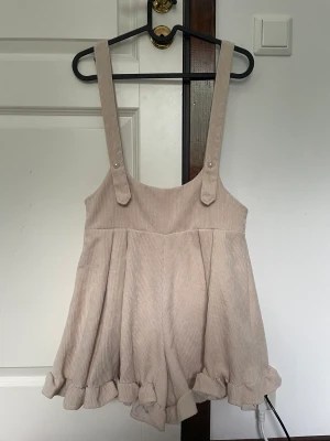 Beige playsuit - En playsuit jag fick av en kompis, jättesöt men den är lite för liten för mig :( typ manchester?