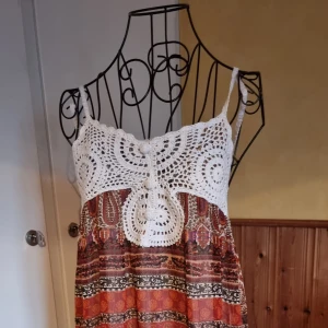 Sommarklänning  - En sommarklänning i polyester och bomull med virkad spets 