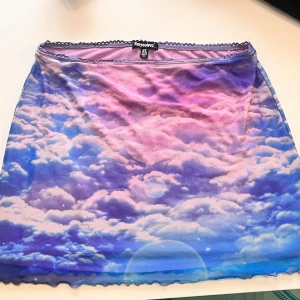 Dollskill kjol stl XL - Kjol från Horoscopez, Dollskill. Märkt Stl XL och bra stretch. inga dragkedjor eller knappar 👌🏻 Sparsamt använd 😔 Inga anmärkningar att göra.  Mjukt material och lätt klädd insida i lila/rosa, jämfört med tillhörande kläder i samma serie.