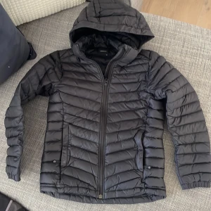Peak Performance Junior frost down hood strlk 150 cl - Säljer en st svart Peak Performance Frost down hood Junior i strlk 150 cl. Lättviktsjacka = tunn dunjacka. Svart logga på svart jacka, köpt på Kidsbrandstore