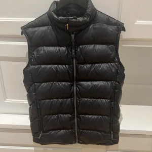 PARAJUMPER dunväst - Dunväst i mycket gott skick. Juniorstorlek: M (passar 165-175 cm) Färg: Svart. Kan skicka fler bilder samt Qrkod 