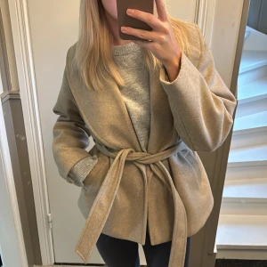 Kappa - Beige kappa med knyte i midjan, storlek L men sitter som en M