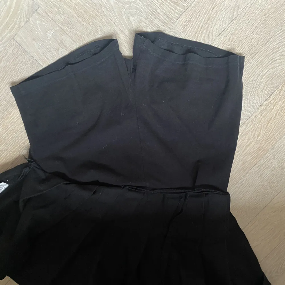 En snygg plisserad svart kjol från Brandy Melville i storlek S. Så snygg! Säljer på grund av att jag har två likadana. Kjolen har även inbyggda shorts vilket är så bra!. Kjolar.