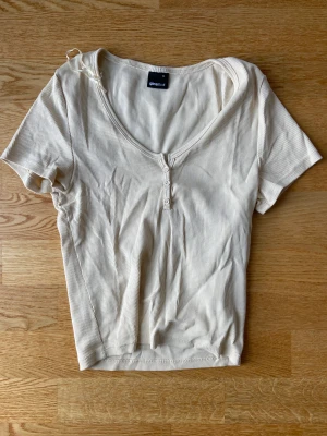 T-shirt - Ribbad t-shirt med urignning och knappar. Från Gina tricot. Använd fåtal gånger och den är för liten för mig nu. Storlek S. Säljer för 70 kr+ frakt. Skriv om ni har frågor.