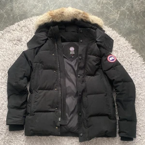 Canada goose wyndham parka  - Jag säljer nu min varma och sköna canada goose jacka. Jag har använt jackan en vinter bara och säljer nu den  pågrund av att den är lite för liten på mig. Jackan är helt ny vilket betyder att det inte är några problem på den, inga hål eller liknande. 
