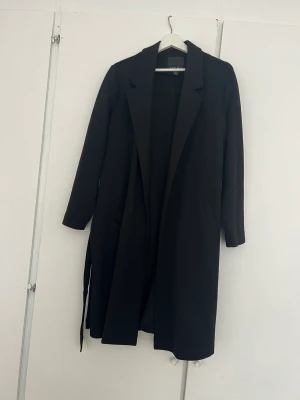 Svart Kappa - Söt vår/höst Kappa i fint skick. Jag är 168cm och den når precis till Vaderna. 