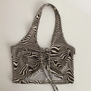 Halterneck top - Vit och mörkbrun-mönstrad halterneck. Fint, lite 70’s vibe mönster. Använd typ 1 eller 2 ggr.