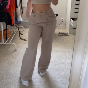 Kostymbyxor - Säljer dessa snygga kostymbyxor i beige. Vida och långa ben som lägger sig snyggt över skorna. Sparsamt använda.❤️❤️