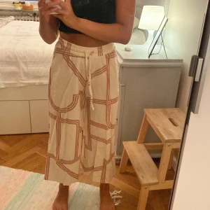 vida mönstrade byxor  - beiga vida byxor med ett rödlistande mönster:) resor och band i midjan, lite kortare byxor!