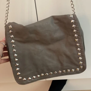 Grå väska  - Den är från Gina me nitar på💓den har ett pytte litet hål på baksidan men inget som man märker typ