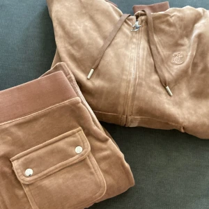 Juicy couture  - Säljer min juicy couture set i mörkbeige/ toffie använda 1 gång och är i nyskick skick!! Storlek S på både byxa och koftan. Nypris för båda är 2300:- 