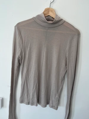 Beige turtle neck top från & Other Stories - Turtlebneck i ull. Sparsamt använd och inga defekter. 