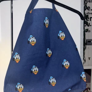 Tygkasse  - 2 styckna tygkassar med Kalle anka på. Min pappa fick dem från sitt jobb och jag har ändast använt väskan på bild 2 några gånger. Båda för 20 eller 15 kr/st 