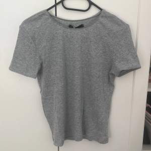 Oanvänd, slimfitting grå t-shirt med prislapp på, för liten för mig så jag säljer den vidare! (frakt tillkommer på 29 kr)