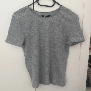 Oanvänd grå t-shirt - Oanvänd, slimfitting grå t-shirt med prislapp på, för liten för mig så jag säljer den vidare! (frakt tillkommer på 29 kr)