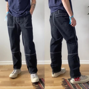 Svarta Loosefit byxor vita sömmar - Fett snygga loosefit byxor, passar som S. Tjejmodell men passar även killar med storlek 28-29 i midja. Två små fläckar men syns knappt. Jag bär byxorna midrise på bilderna. För fler bilder eller mått kontakta mig! 💫