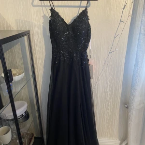 Svart balklänning med paljetter  - En superfin svart balklänning med paljetter och glitter upp till, och en slits nertill. Från JJs house. Bara testad aldrig använd. Inköpt för 1800kr, säljs för 1200kr men pris kan diskuteras. Stolek 34☺️