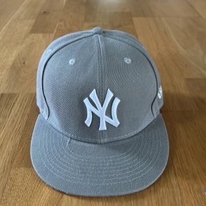 Grå new era yankee - Knappt använd keps, nyskick, storlek 7/55.8. Hör av dig om du har frågor eller är intresserad!
