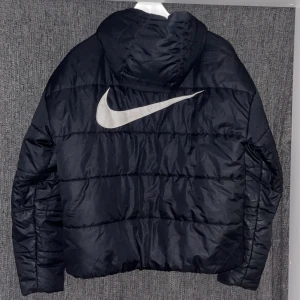 Nike Vinterjacka  - Superfin vinterjacka i dun ifrån nike med ett stort och tydligt nikemärke på ryggen. Enda defekten på den är att spetsen på nikemärket är borta (se sista bilden) bara skriv för fler bilder eller om ni har några frågor💕Köptes inför förra vintern för 1200kr
