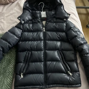 Moncler Maya -  moncler maya jacka i ny skick, köpte på NK i vintras men inte min stil längre. Super fin passar mig som är en S är 168cm, men är en strl 14 vilket motsvarar en xs/s i vuxen storlek. Har qr kod, tag, och prislapp kvar 💘💘 nypris: 9635kr( fler bilder finns)