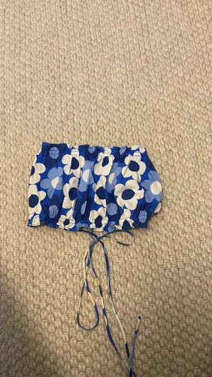 Topp från Zara  - Liten topp med blåa blommor och snörning i ryggen från Zara och är nästan aldrig använd och har inga fläckar eller hål 