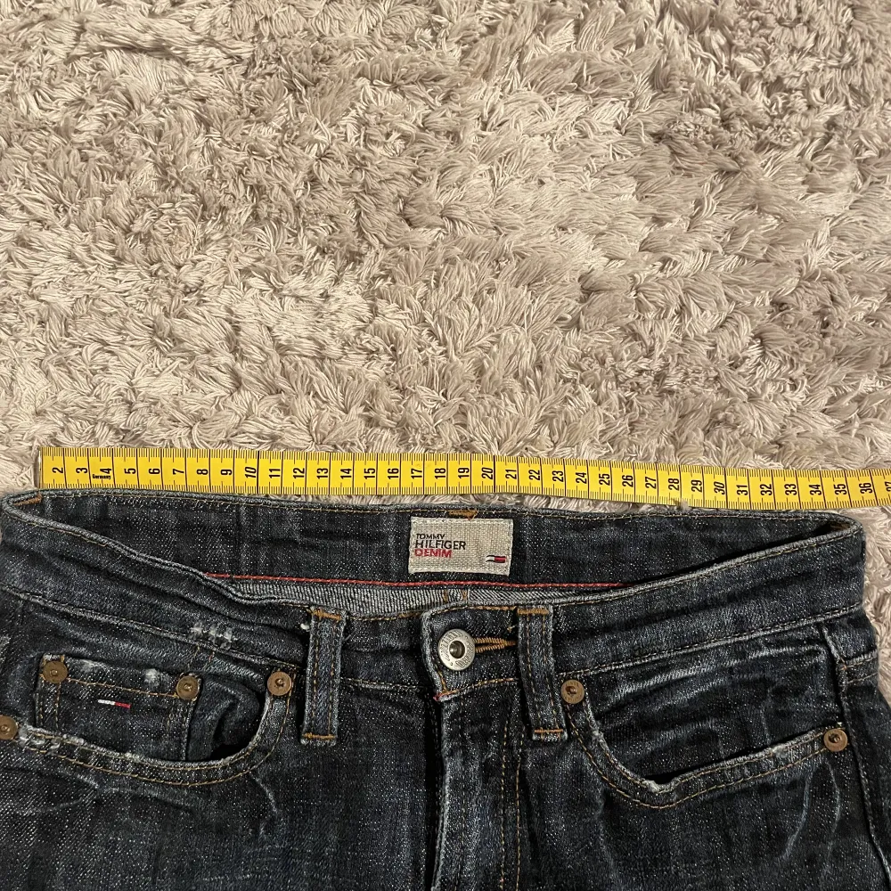 Suupersnygga bootcutjeans från Tommy Hilfiger med en del slitningar längst ned vilket jag bara tycker är snyggt. Kan skicka bild om det önskas💕 Lowwaist med innerbenslängd 75 cm, W25, L32. Jeans & Byxor.