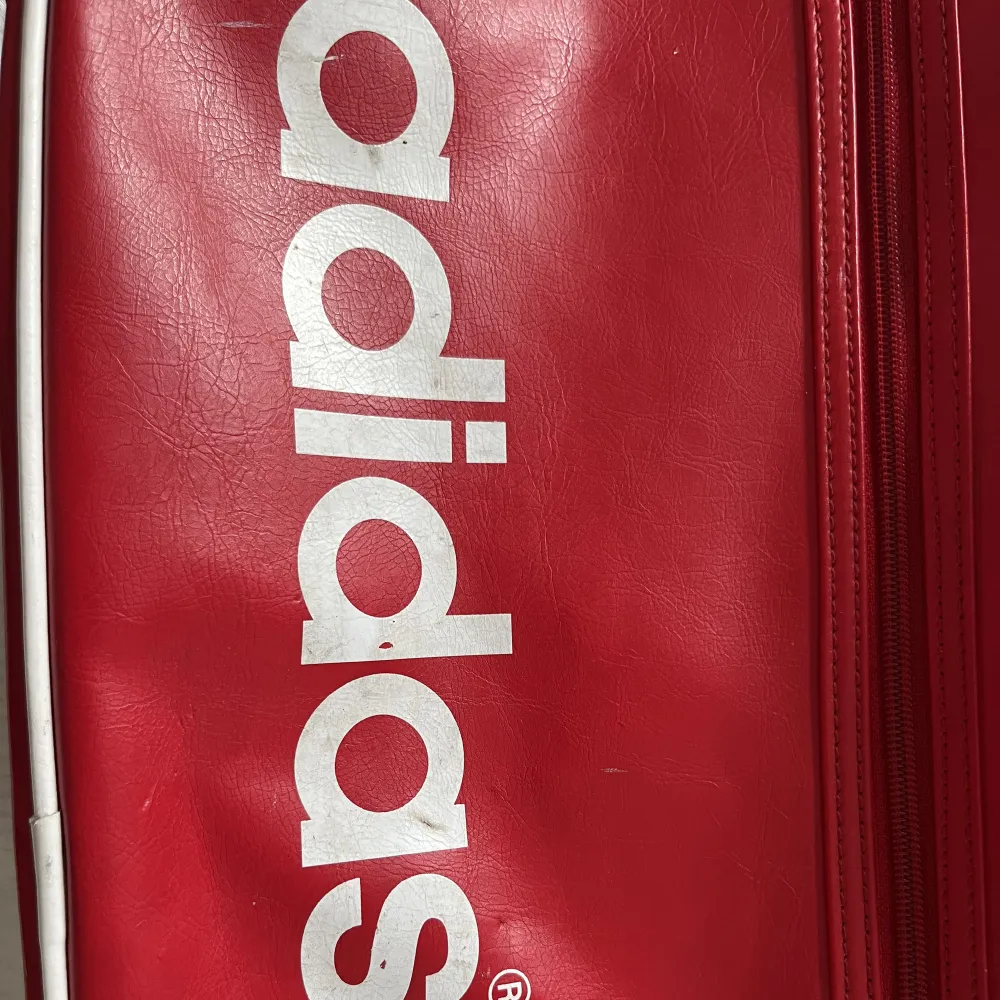 Adidas retro axelremsväska i röd. Väskan har några fläckar men i övrigt i bra skick. . Väskor.