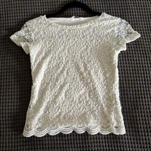 En vit spets t-shirt med undertröja så den är ej genomskinlig, bra skick 