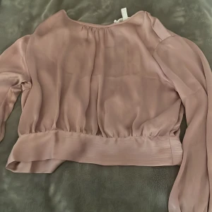 Rosa blus  - Rosa blus med öppenrygg och knytning där bak. Aldrig använd, nyskick. 