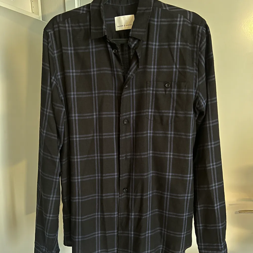 Hej! Säljer nu en Overshirt/Skjorta från Samsøe i nyskick. Den är svart med trendigt mörkblått flanell tryck!   Hör av dig vid frågor. Skjortor.