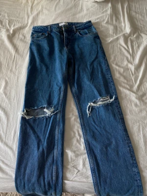 Blåa jeans - Blåa jeans med hål vid knäna