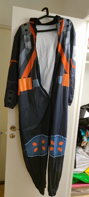 Bakugo Katsuki Jumpsuit Dräkt My Hero Academia - Säljer en "One piece" / Jumpsuit dräkt som ska föreställa Bakugou Katsuki's kläder. Är nästan som en pyjamas. Men kan användas till annat också.  Är mjuk och skön. Storlek XL.  Säljes då den var för liten för mig. I nyskick. 
