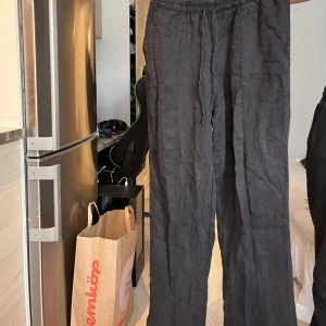 Svarta linnebyxor - Svarta baggy linnebyxor med fickor. Använda en del men fortfarande i bra skick. Lappen är bortklippt men tror att dom är i storlek 36. Ganska stora i storlek och långa i benen. 