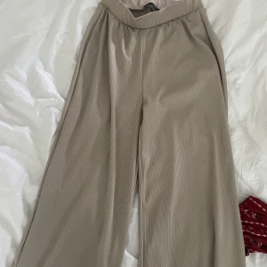 Byxor - Liknade kostymbyxor, ribbade, beige i färg. 