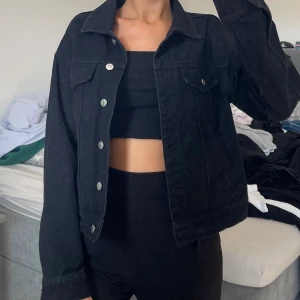 Svart jeansjacka - Supersnygg svart jeansjacka från na-kd som knappt är använd. Storlek 40 men den sitter snyggt oversize 
