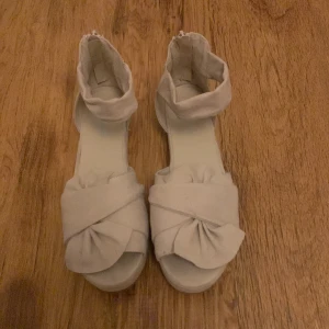 Sandal med hög sula och moka liknande material. - Beige färg, storlek 38, använda 2 gånger, med drag kedja!